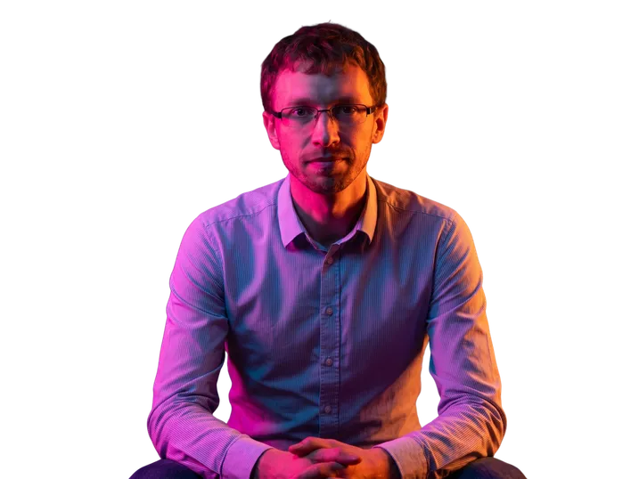 Portrait de Nicolas Boissel-Dallier, cofondateur et CTO de BeretPlan, mains croisées sous un éclairage néon violet